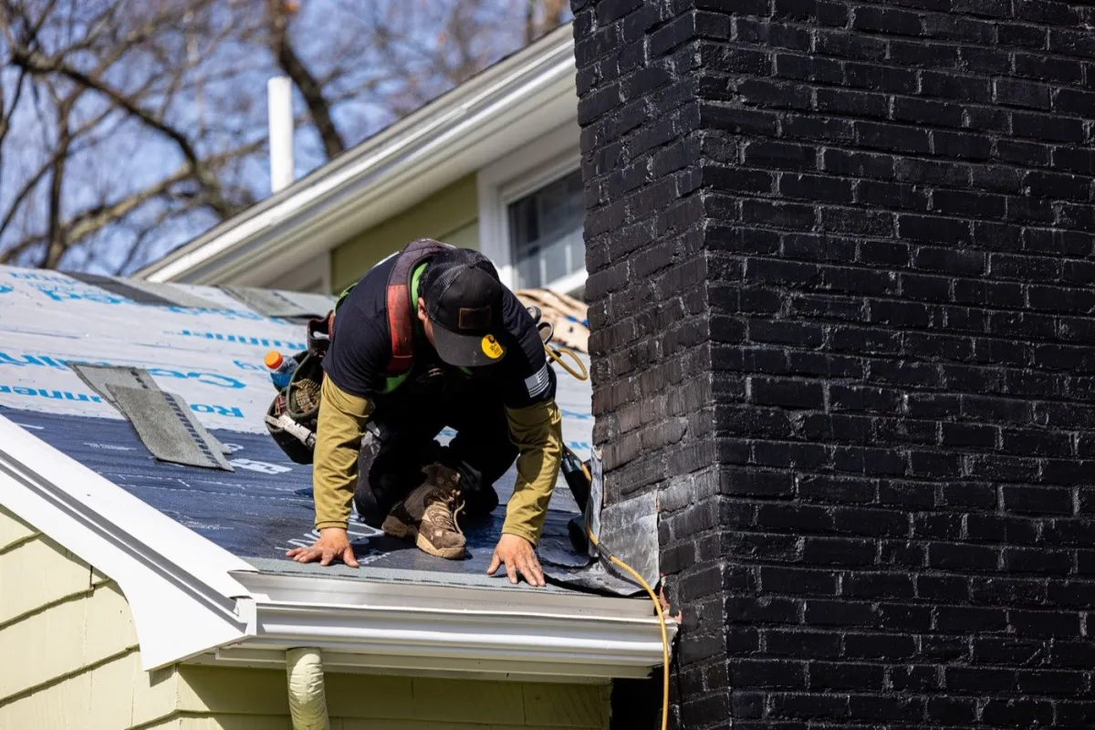 Senco roofing crew on a steep asphalt shingle roof near Billerica, MA — the roof style most prone to winter ice dams